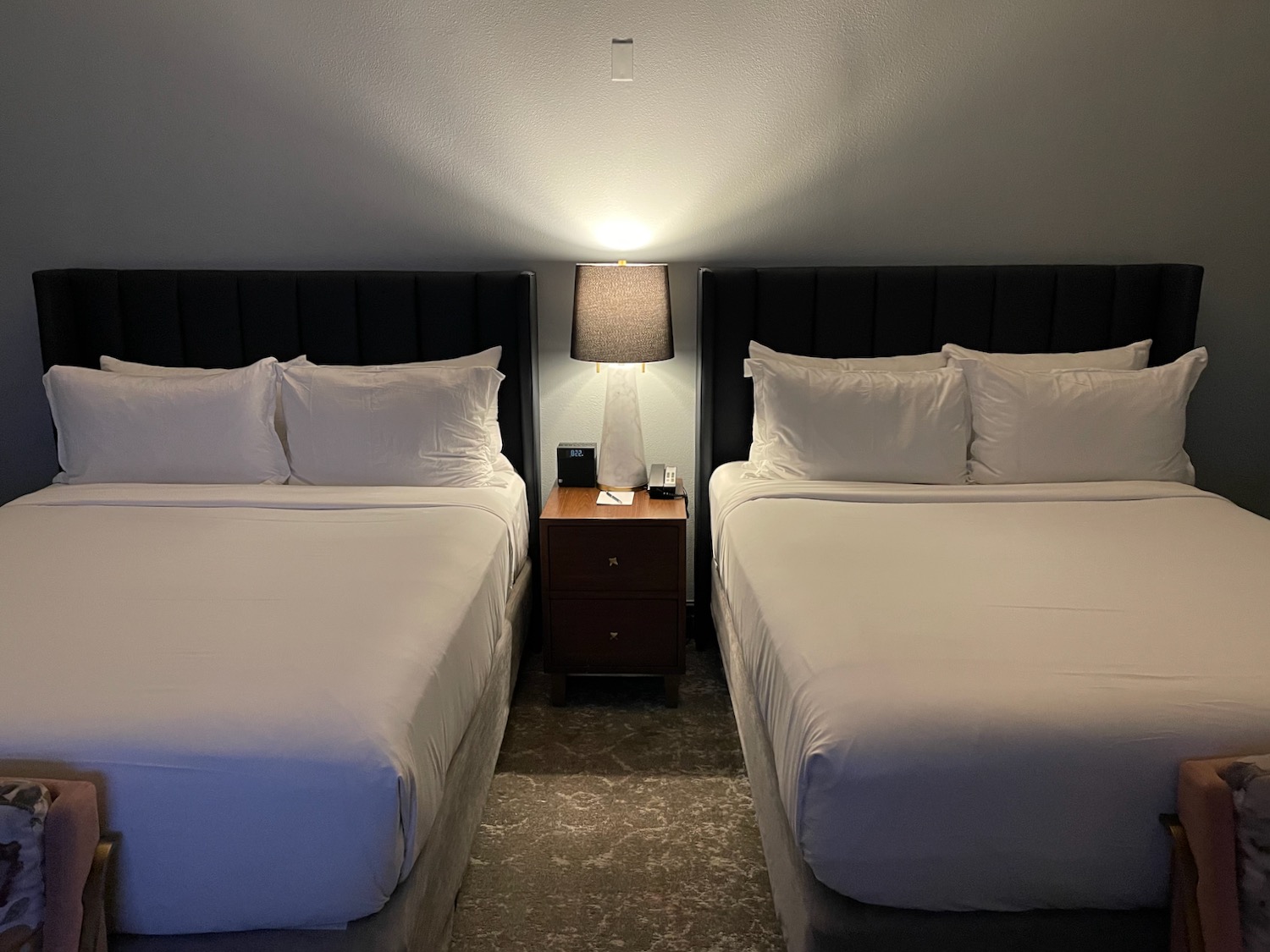 two beds with white sheets and a lamp