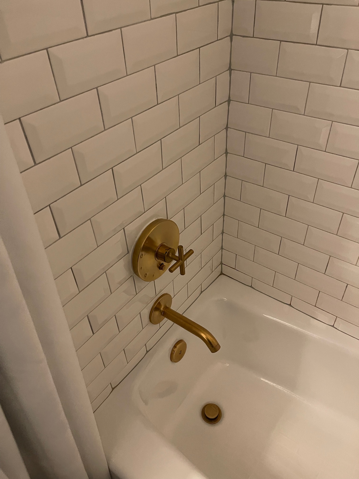 a bathtub with gold faucet and a shower