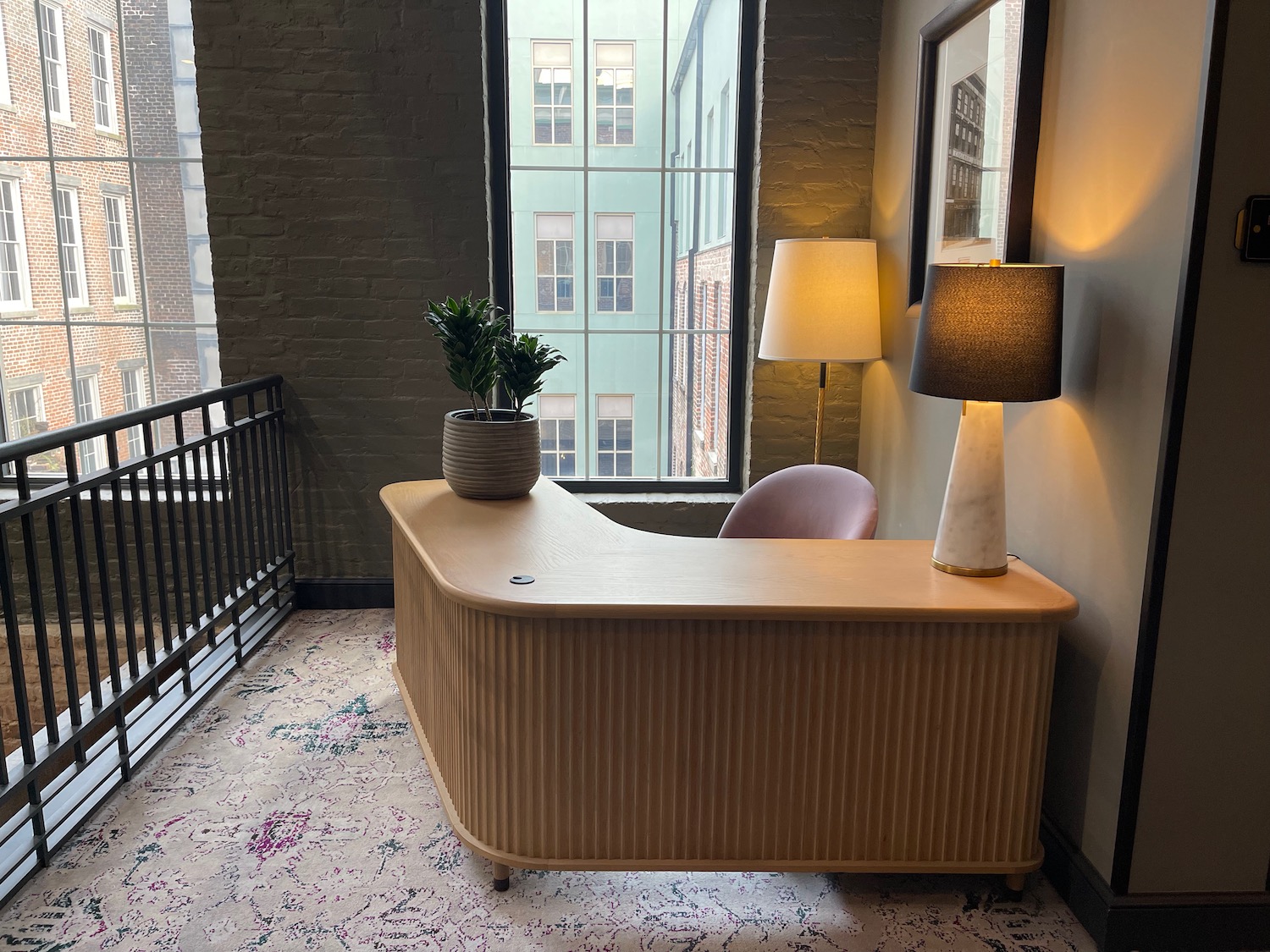 a desk with a lamp and a plant on it