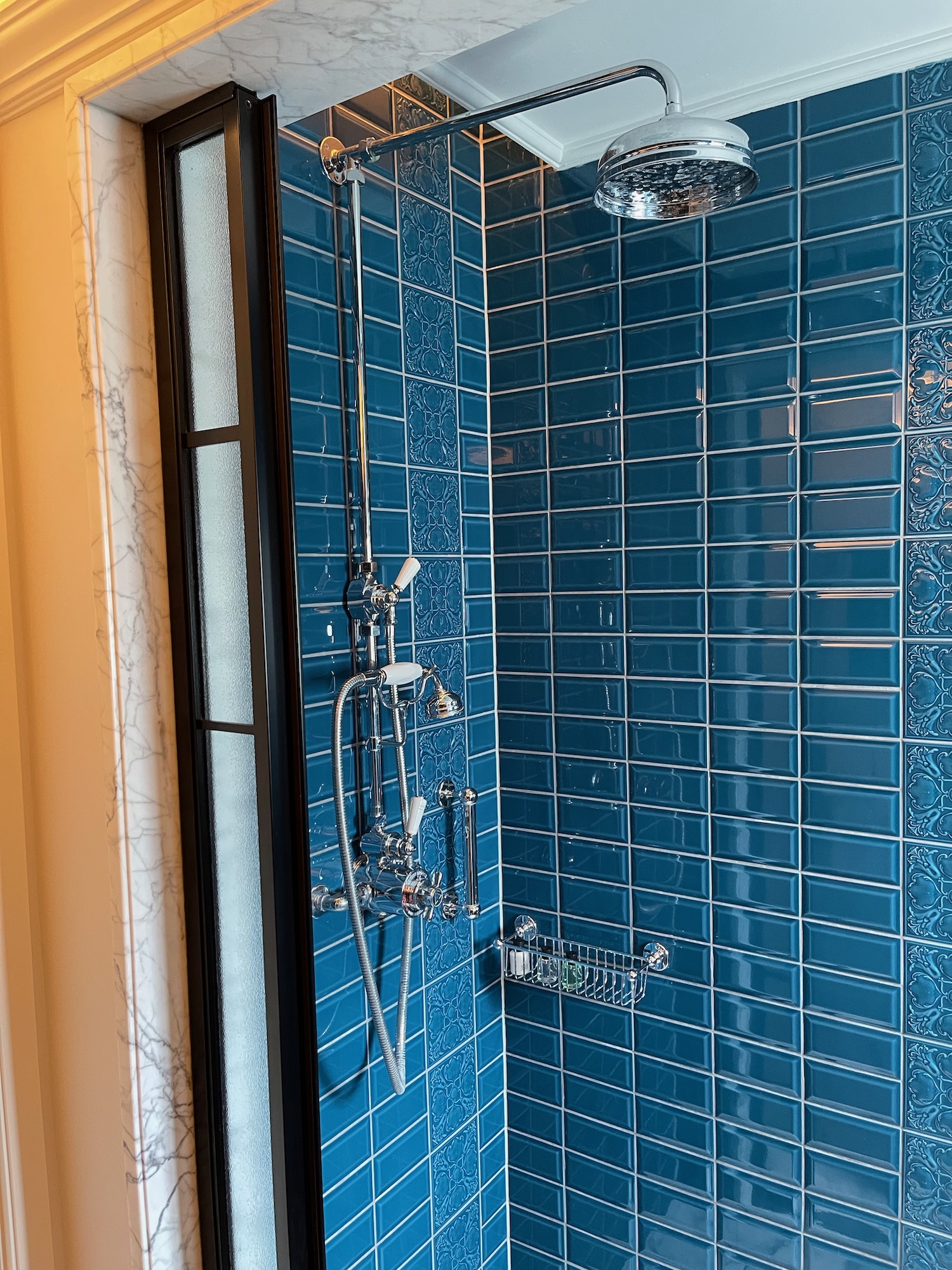 a shower with blue tile