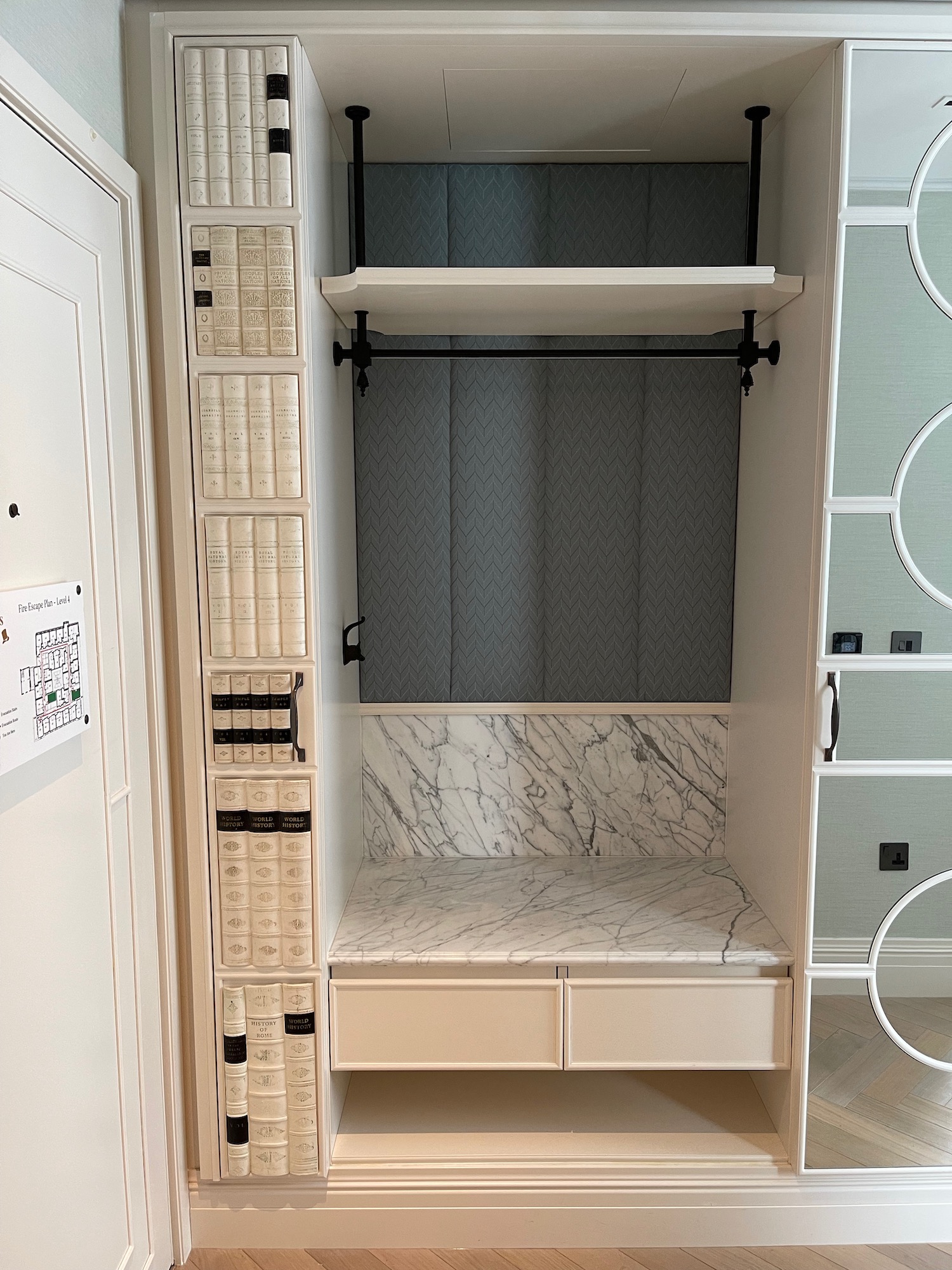 a white closet with shelves and a bench