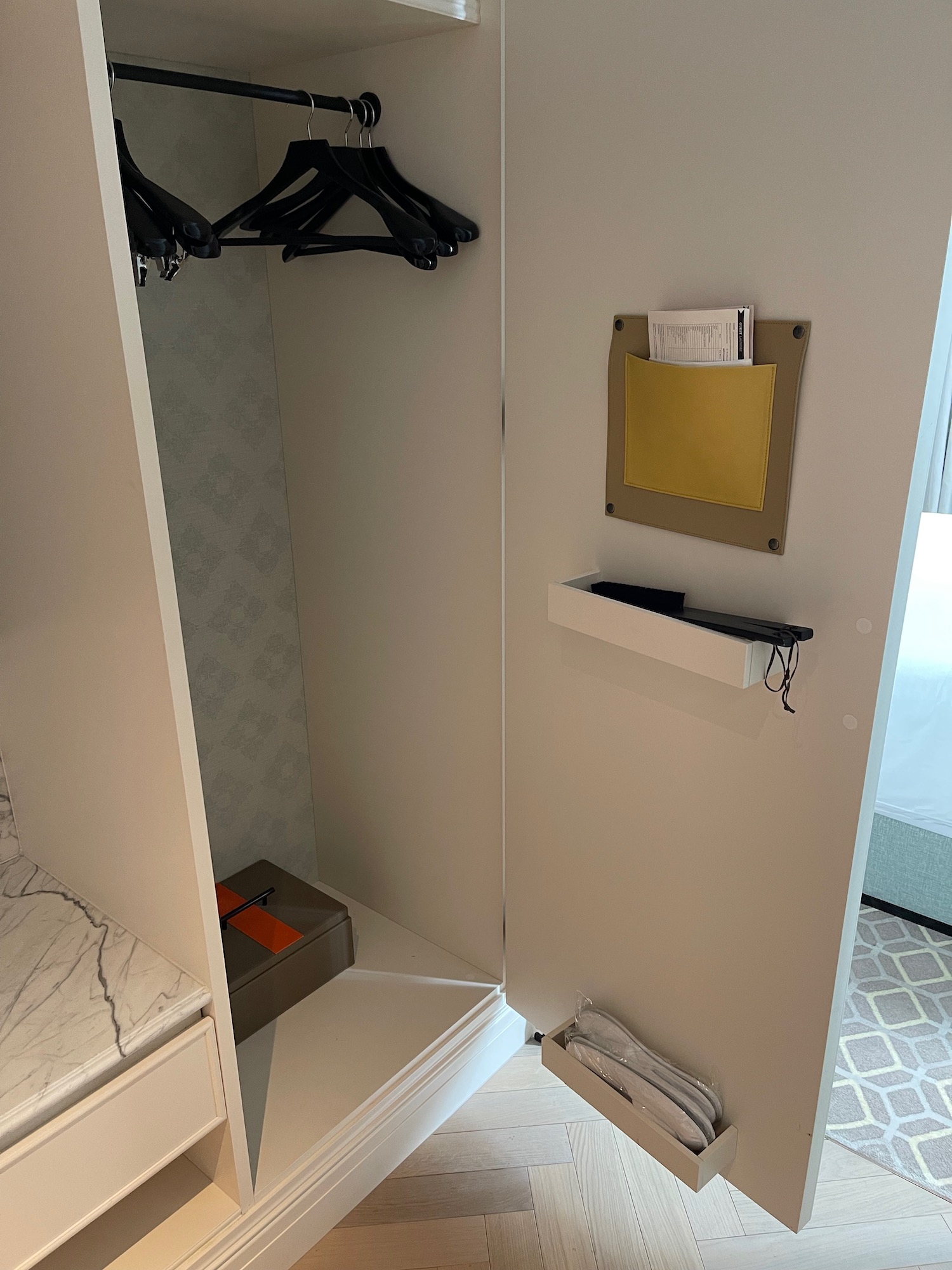 a closet with a door open and a shelf with clothes on it