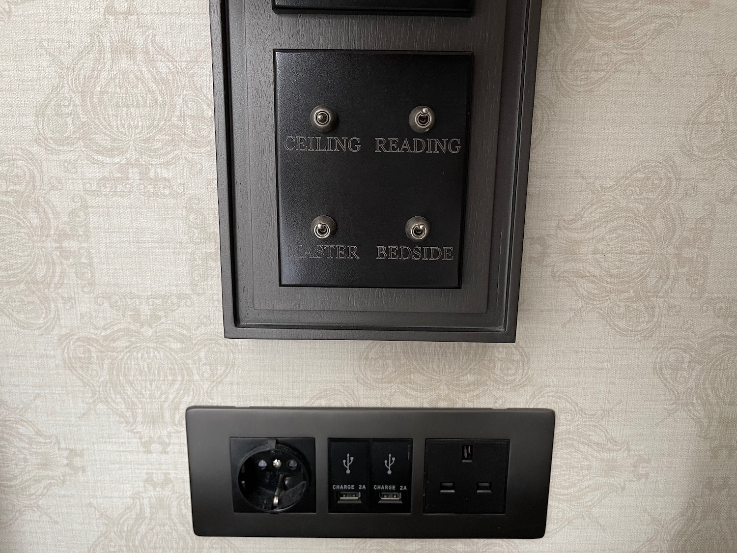 a black rectangular box with silver buttons and a black outlet