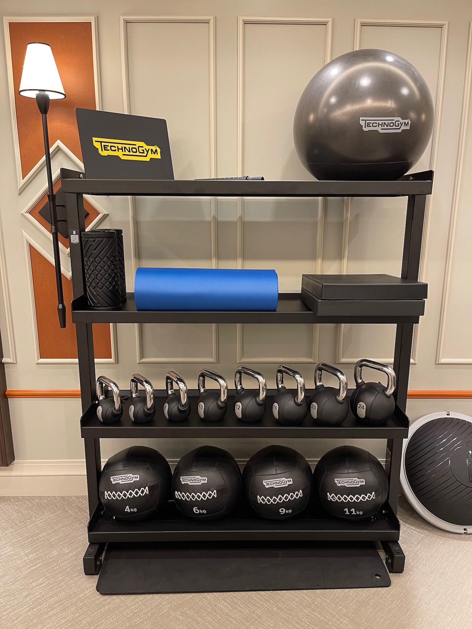 a shelf with kettlebells and exercise balls