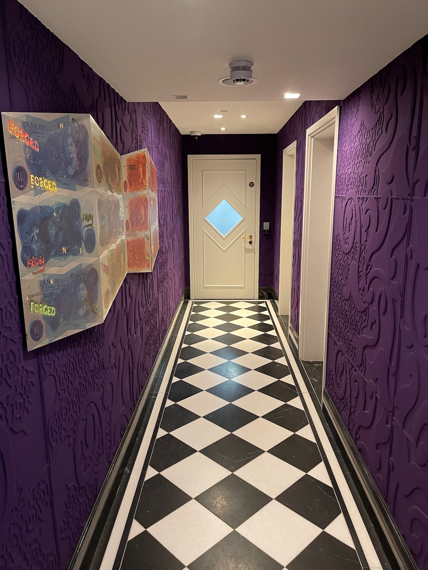 a hallway with a white door and purple wall