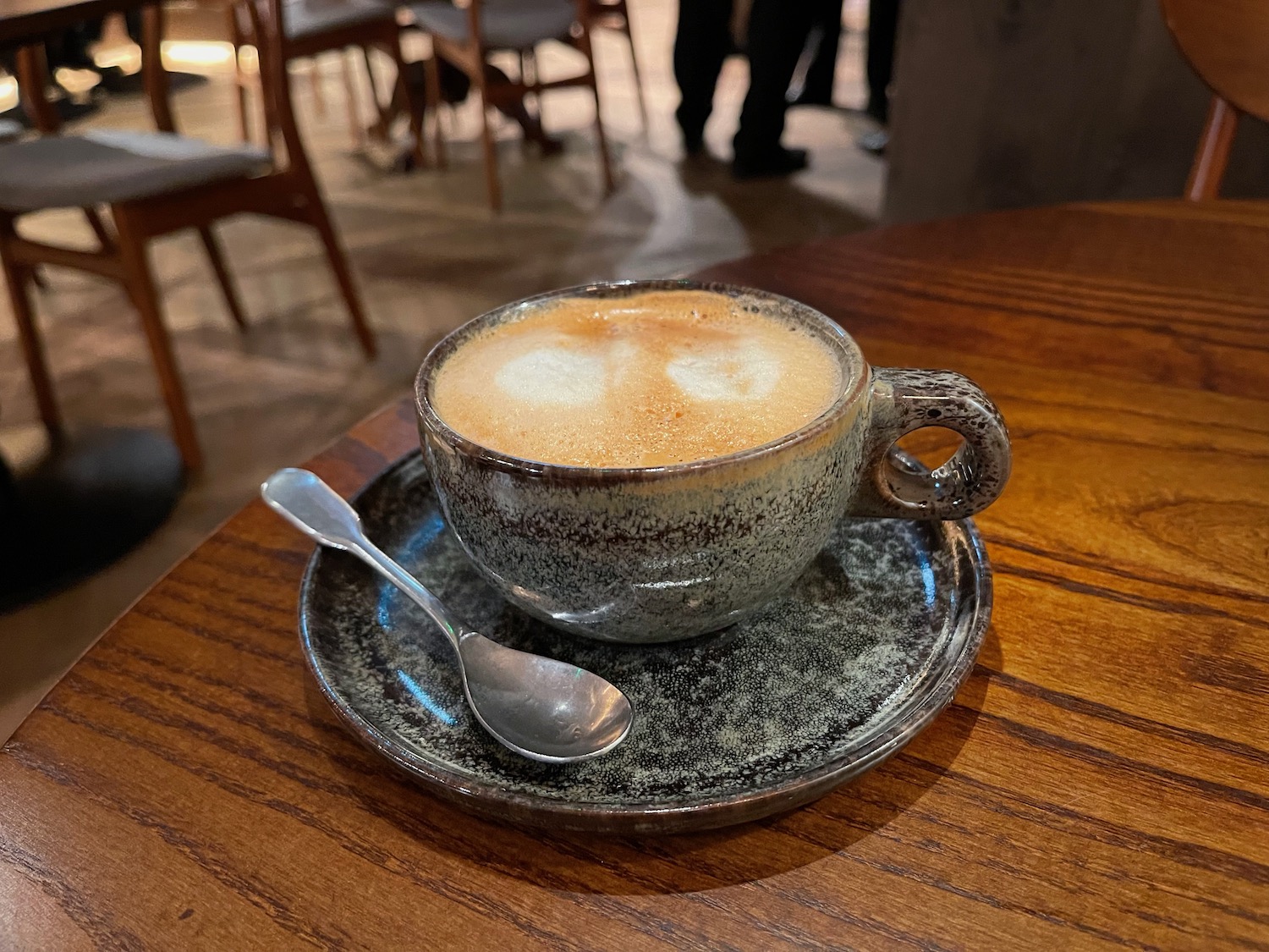 a cup of coffee on a saucer with a spoon