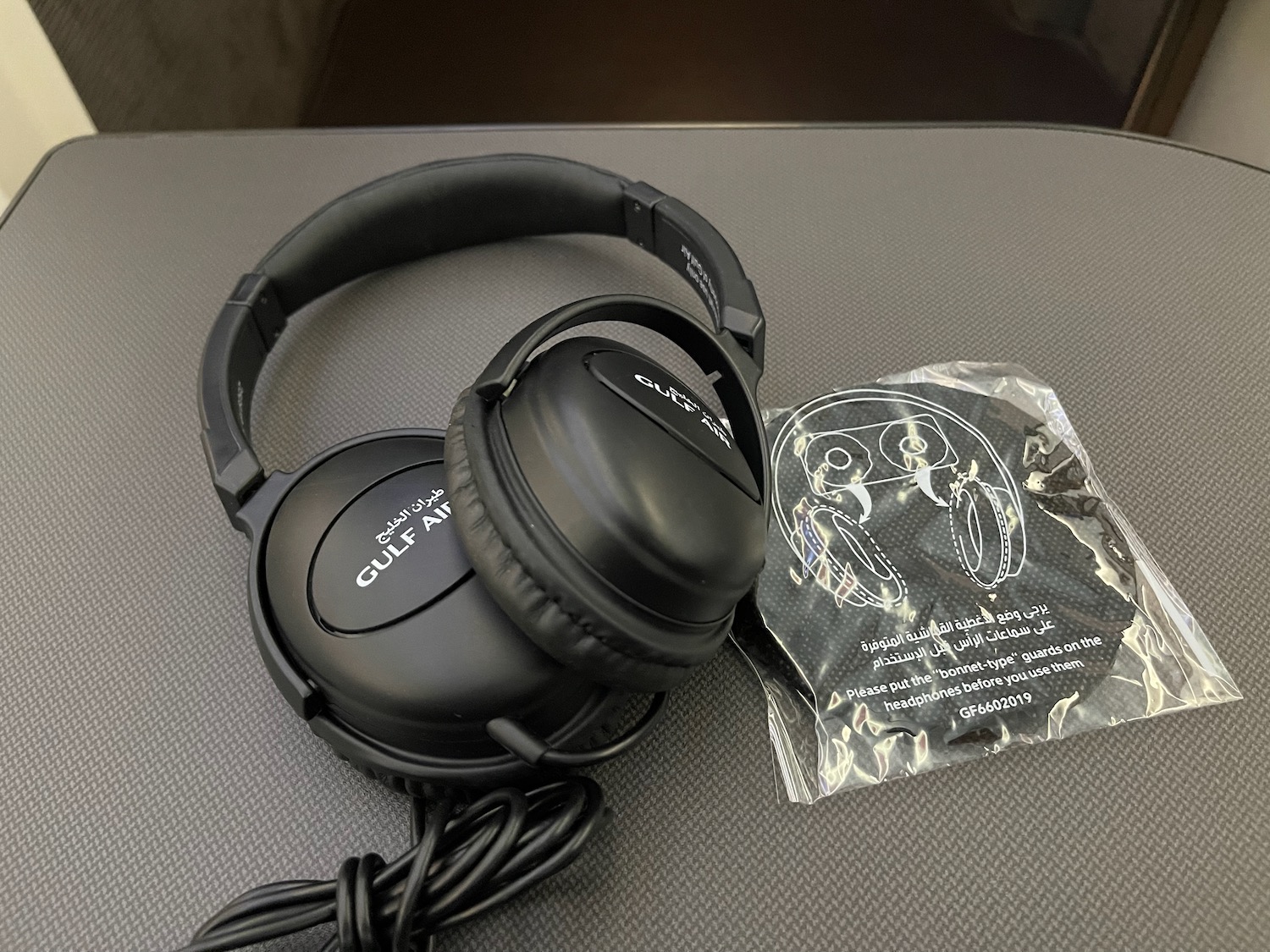 a pair of black headphones on a grey surface