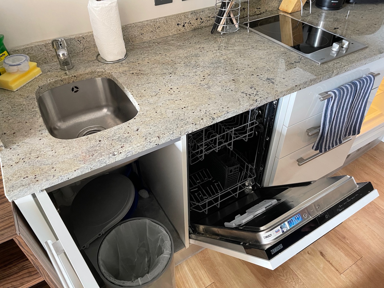 a kitchen counter with a sink and a dishwasher