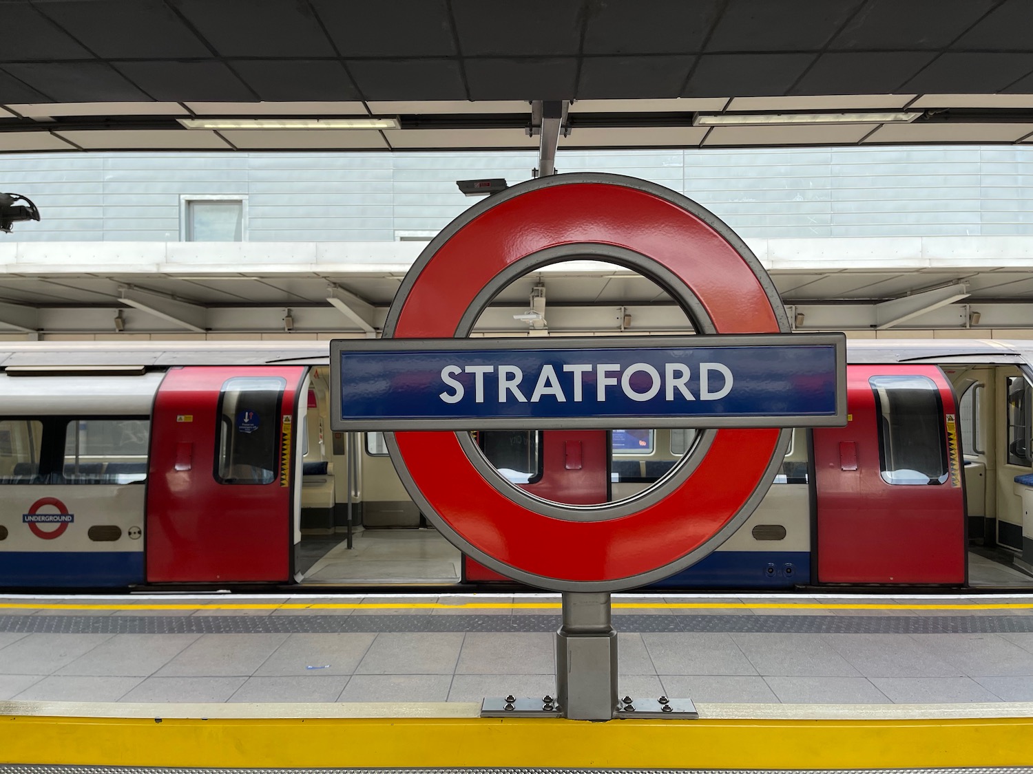 a sign at a train station with London Underground in the background