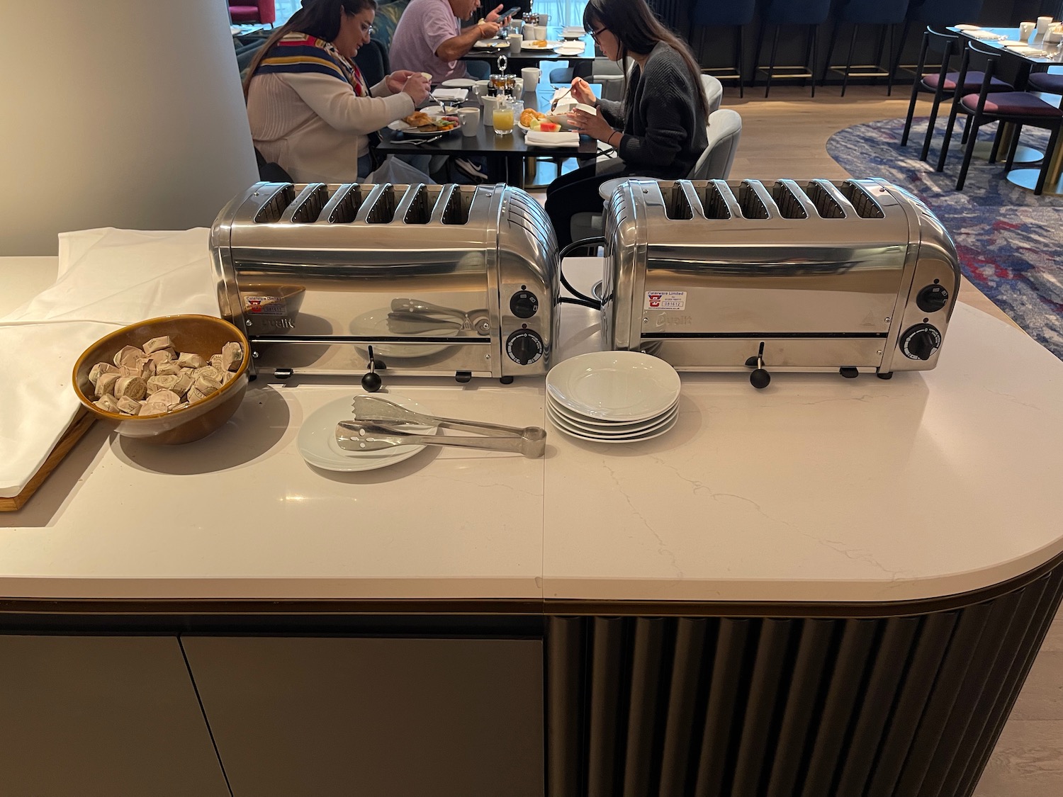 a group of people sitting at a table with toasters