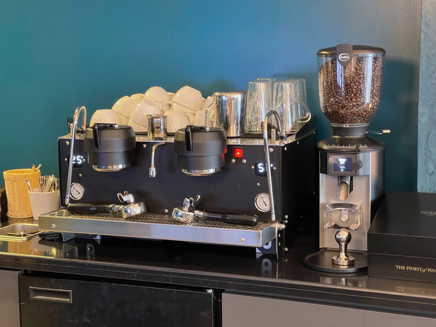 a coffee machine with coffee beans and cups on a counter