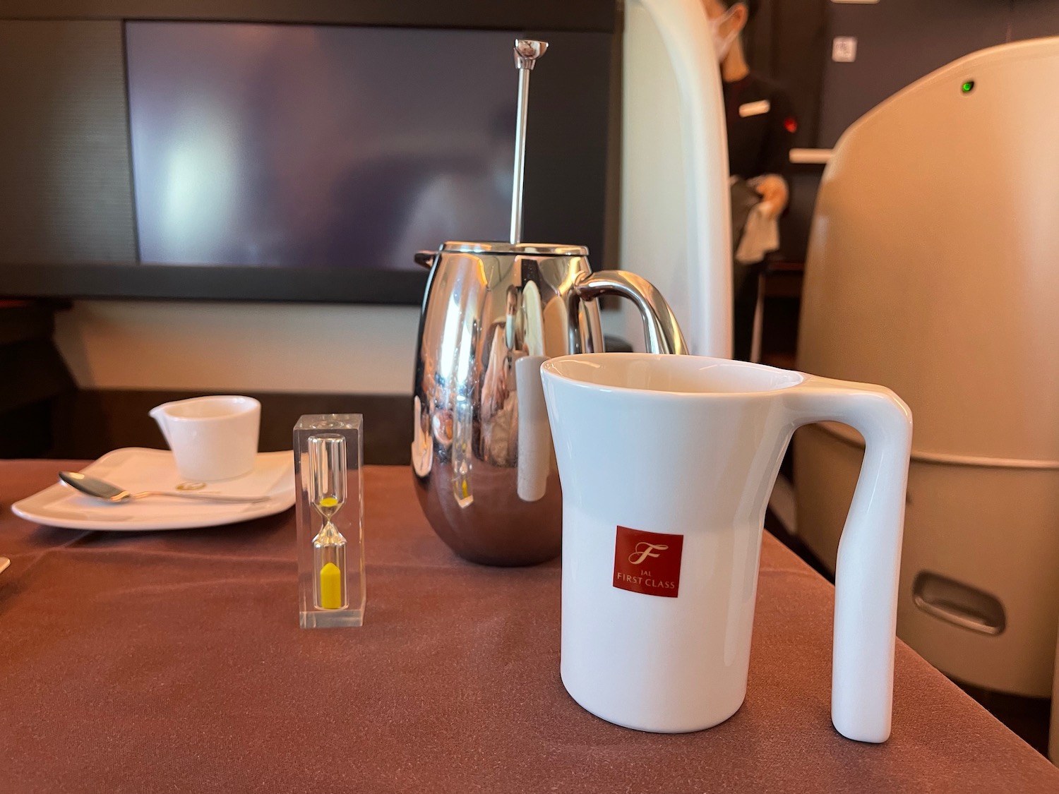 a white pitcher and a silver pitcher on a table