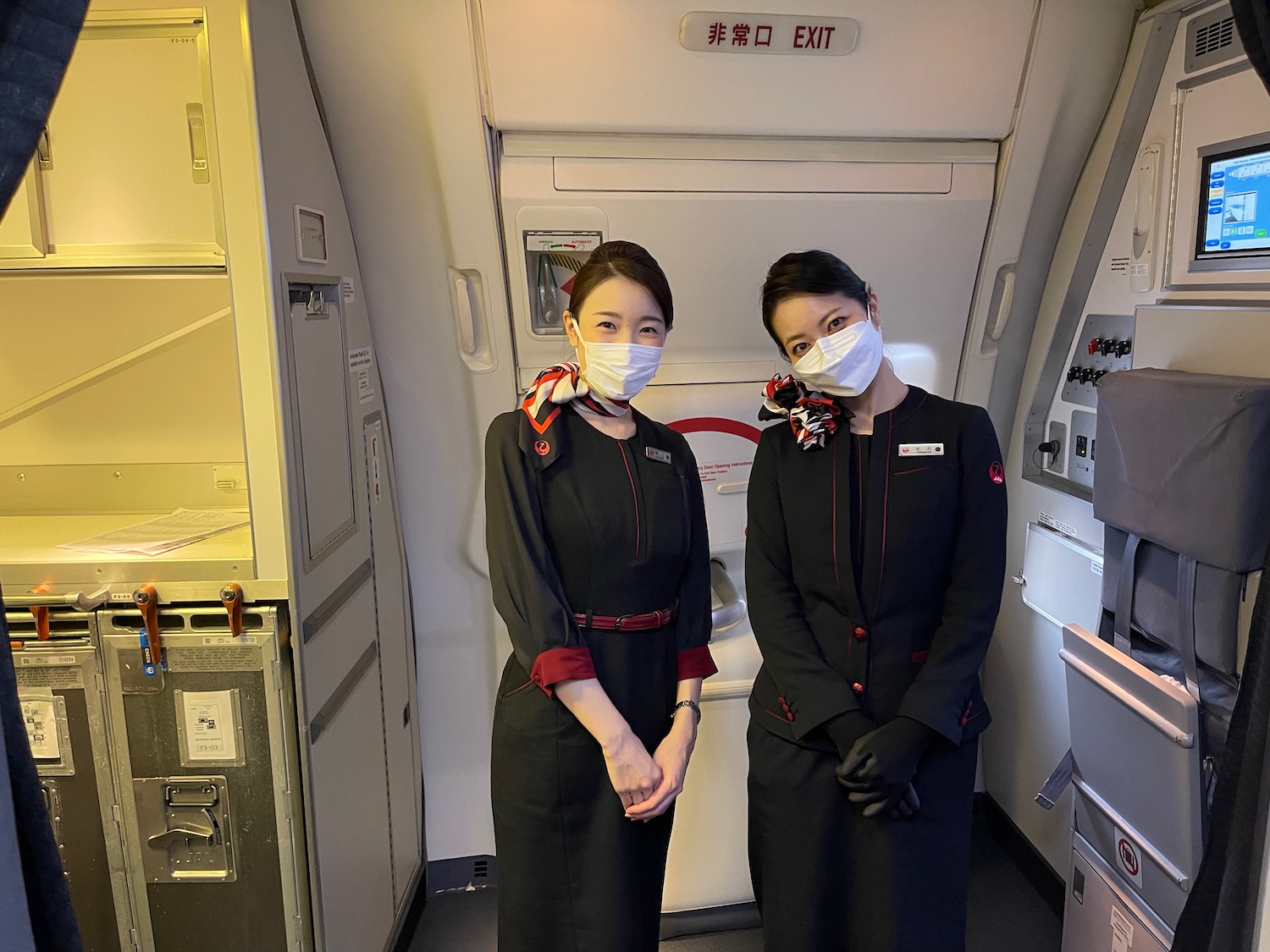 two women wearing face masks in an airplane