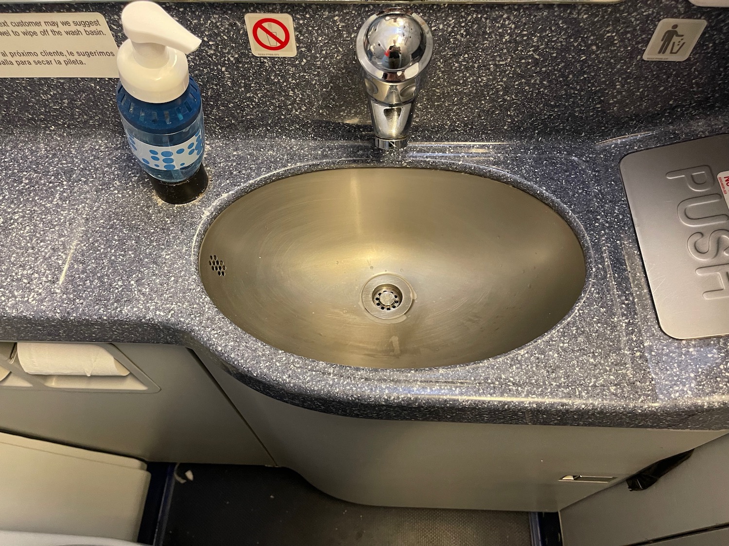 a sink with soap dispenser and a bottle of liquid