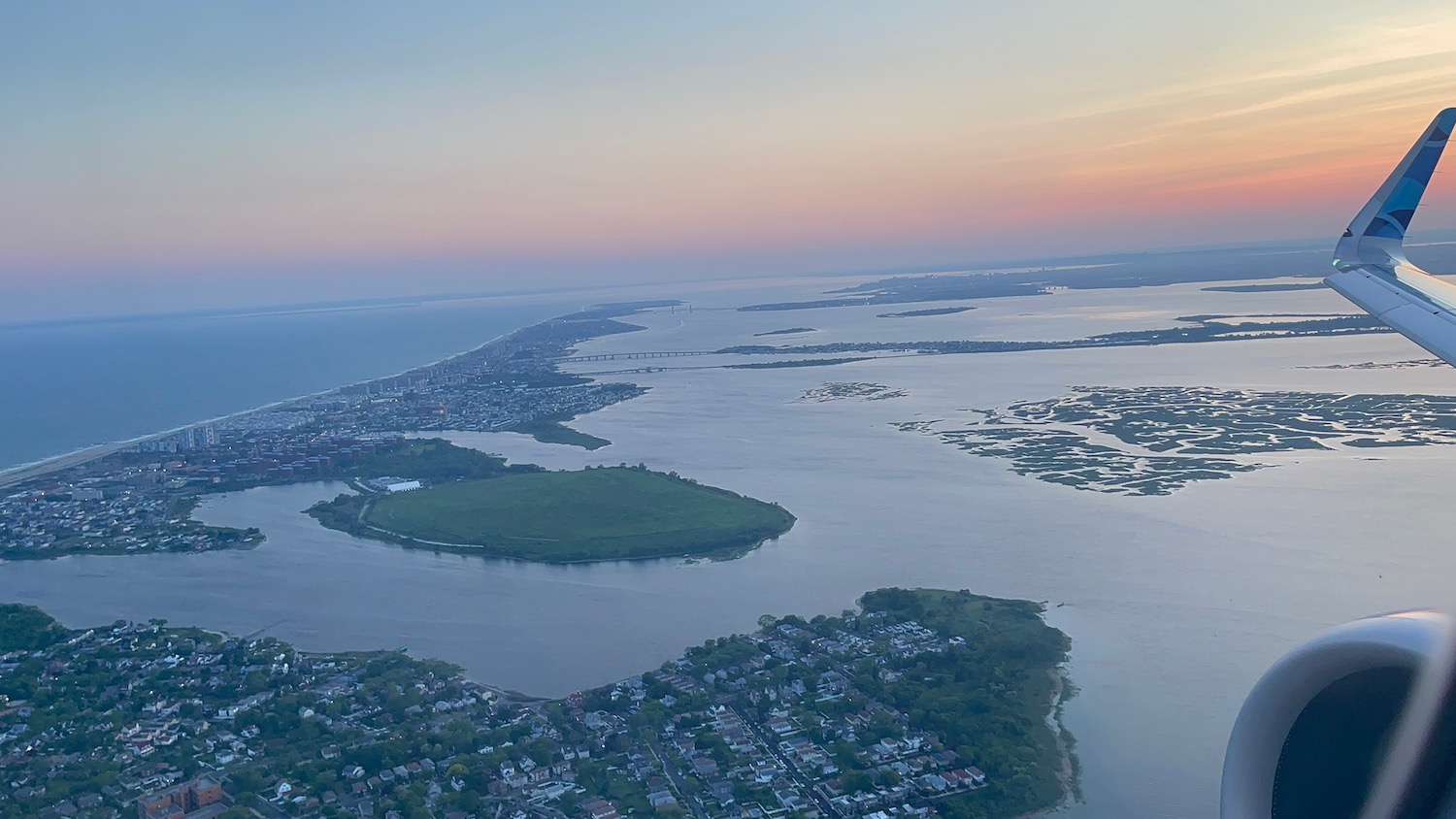 an aerial view of a body of water with land and buildings