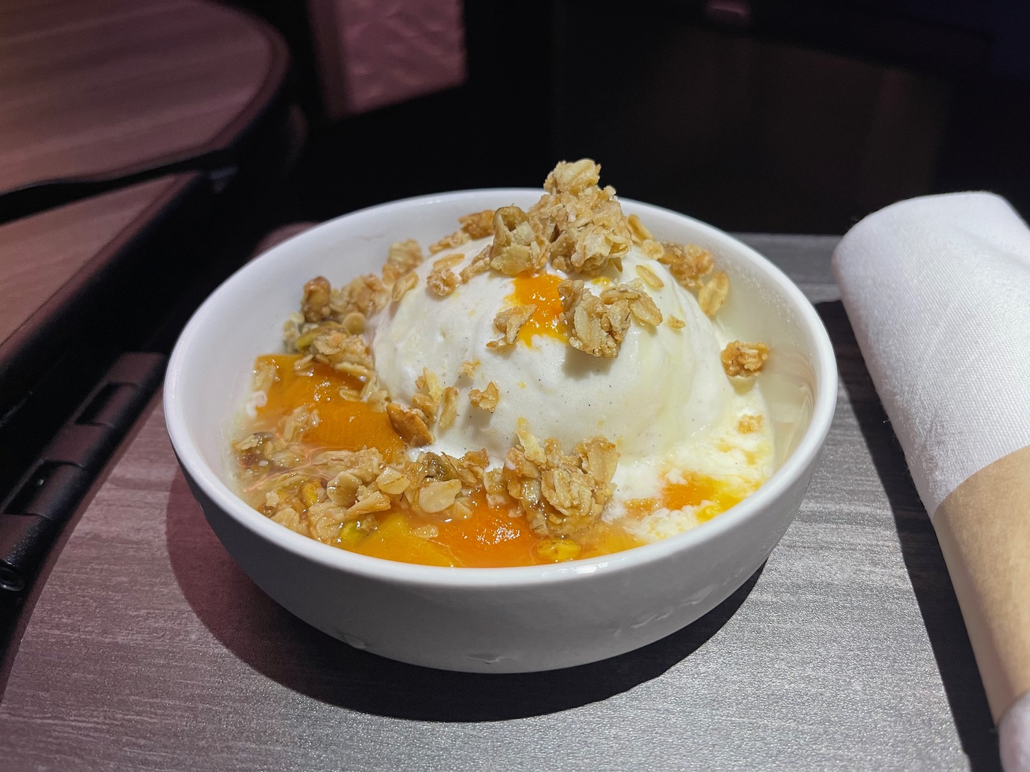 a bowl of ice cream with granola and a napkin