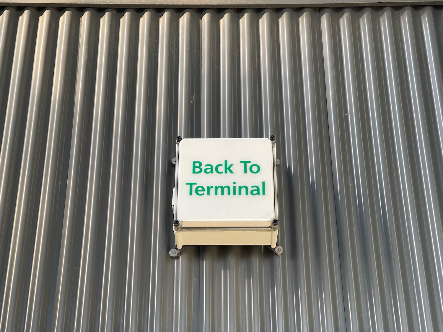 a white box with green text on a metal surface