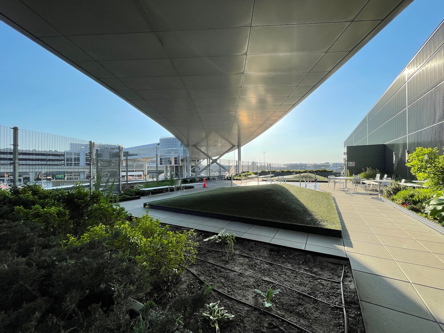 a building with a roof and plants