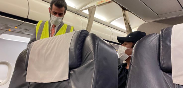 a man wearing a mask and standing next to a man wearing a mask