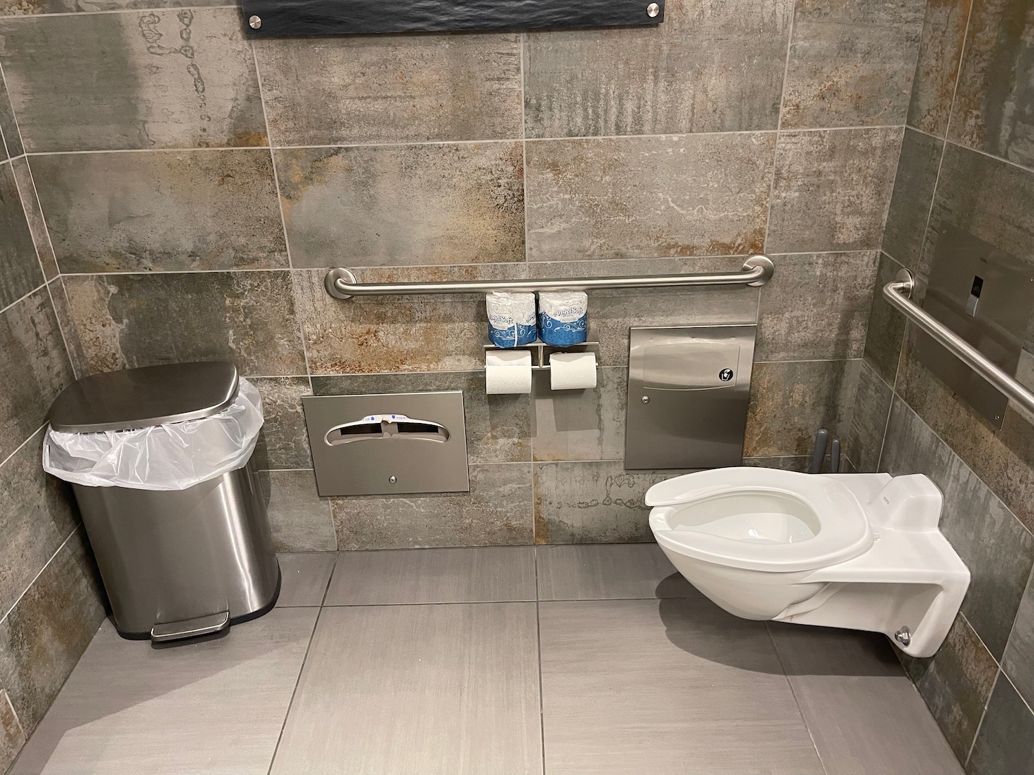 a bathroom with a toilet and trash can