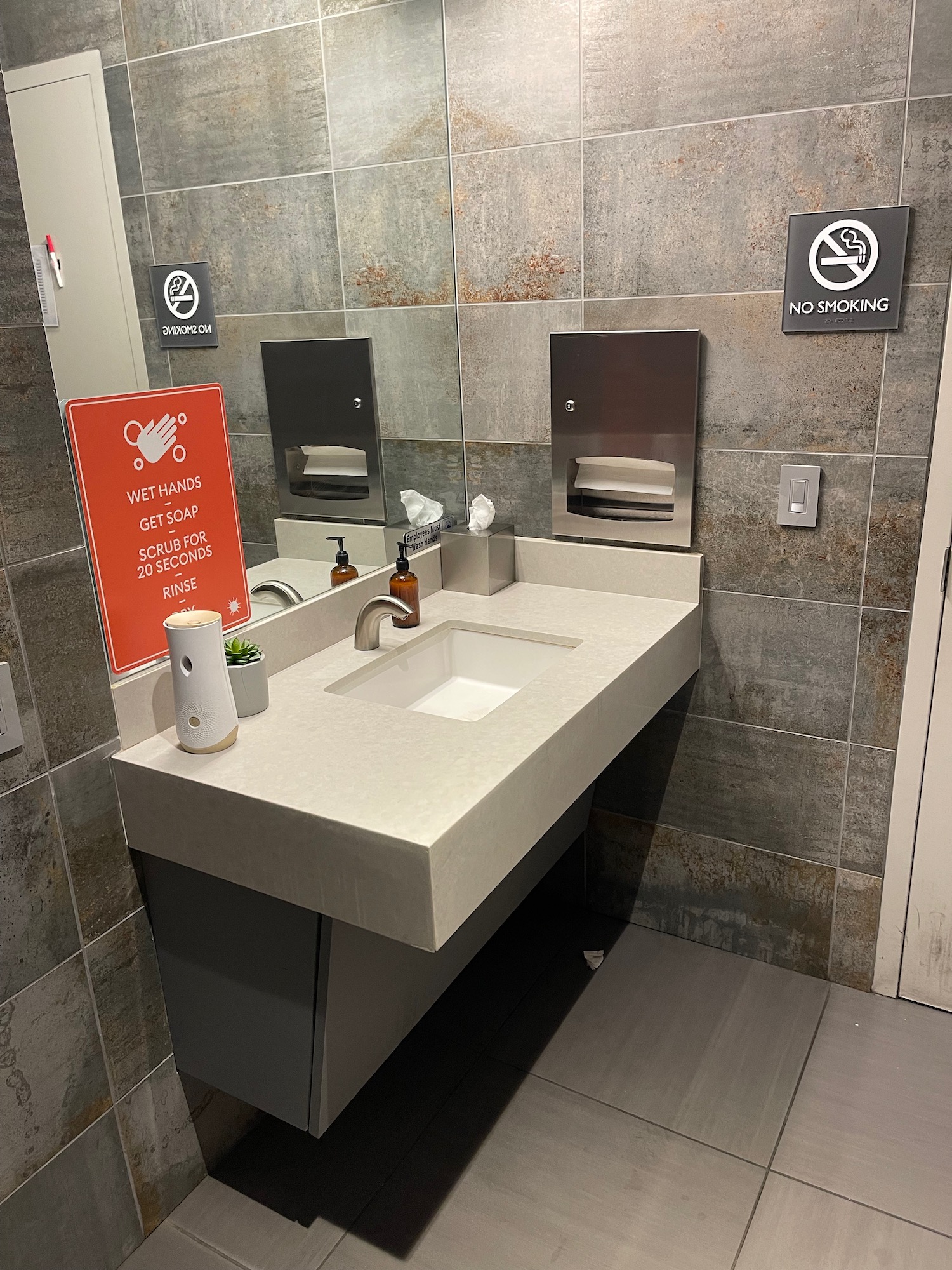 a bathroom sink with a sign and a mirror