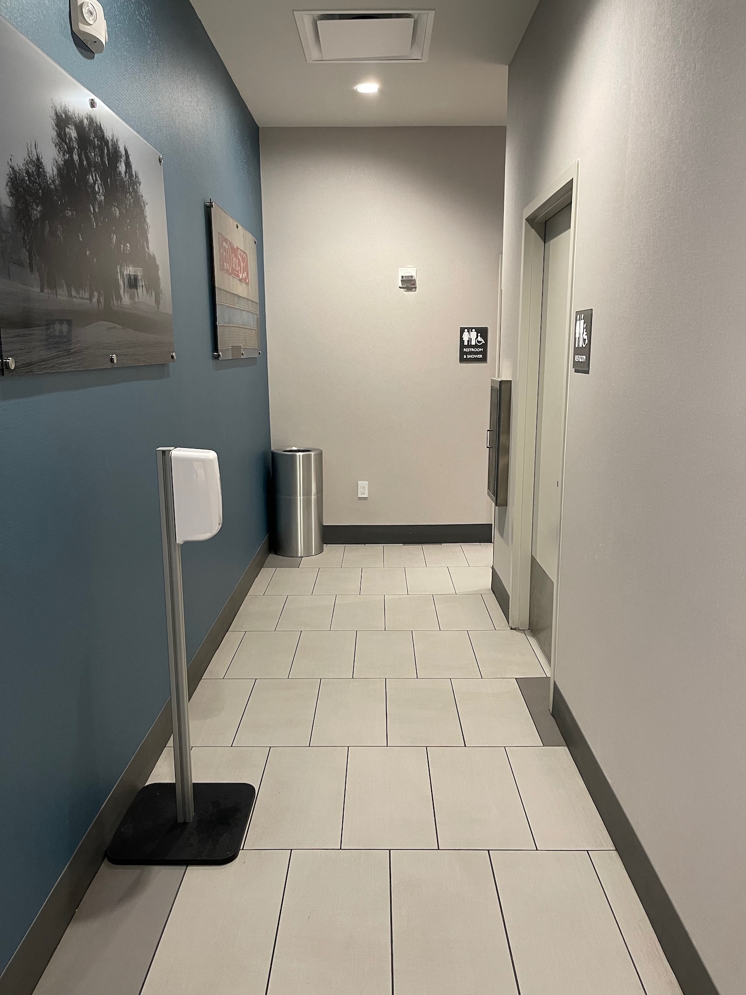 a hallway with a metal pole and a trash can