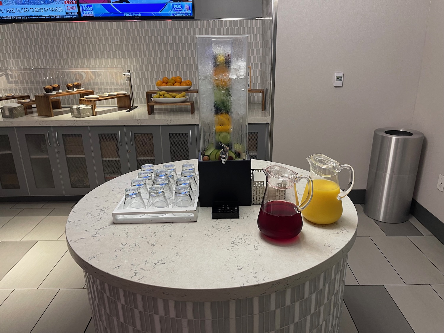 a table with a drink dispenser and glasses