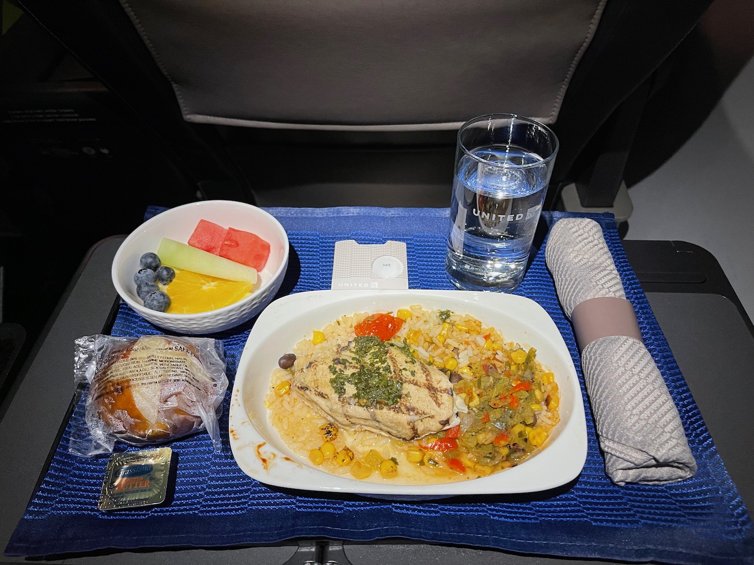 a tray with food and a glass of water on it