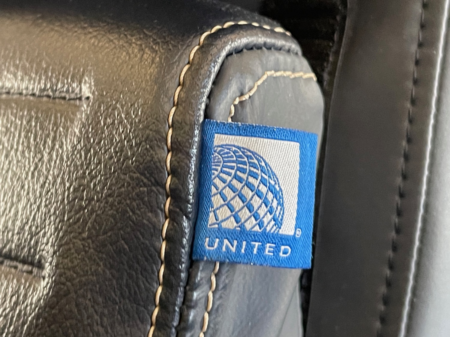 a close up of a blue label on a black leather chair