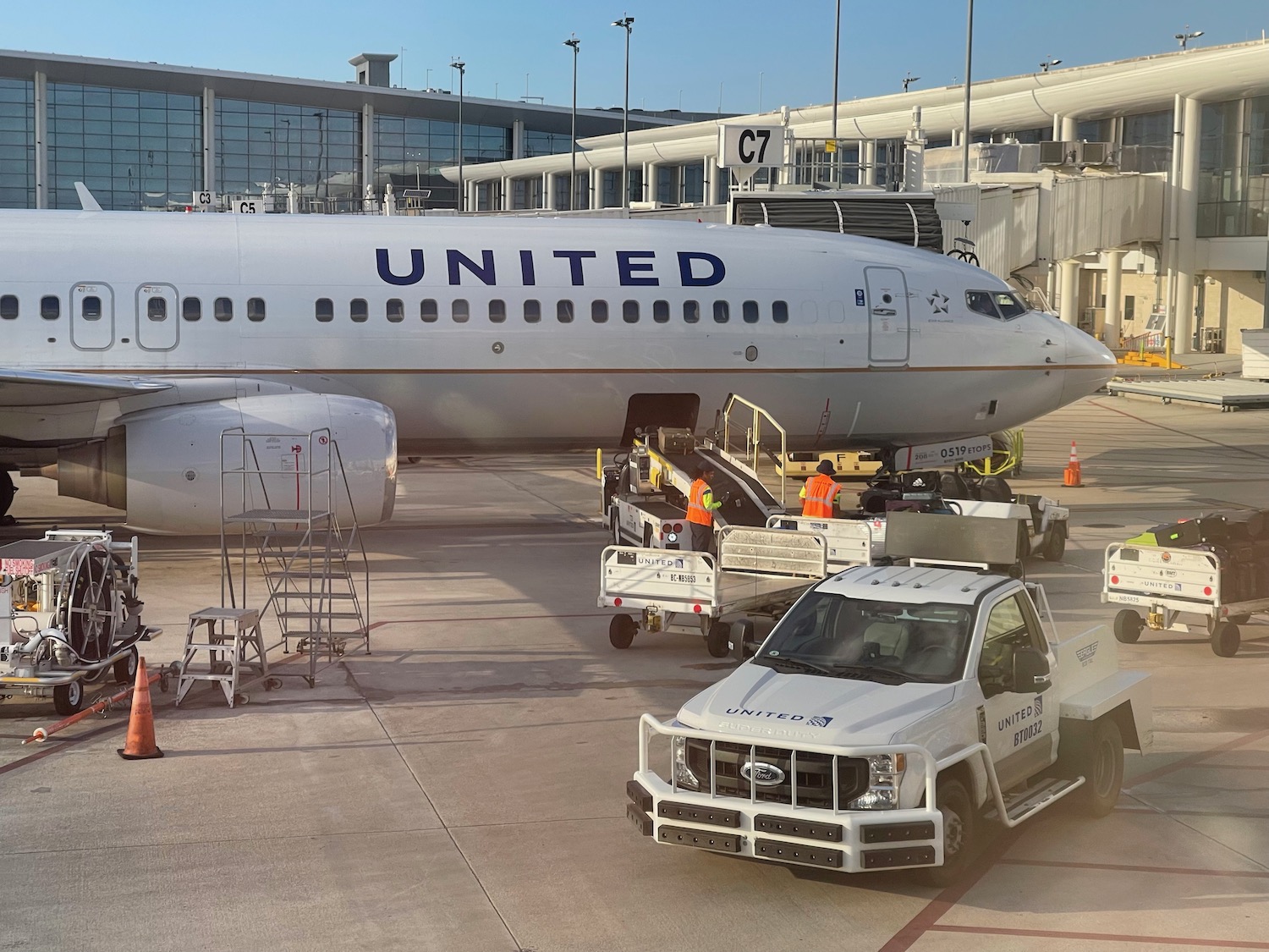 a white airplane with a truck and a ladder