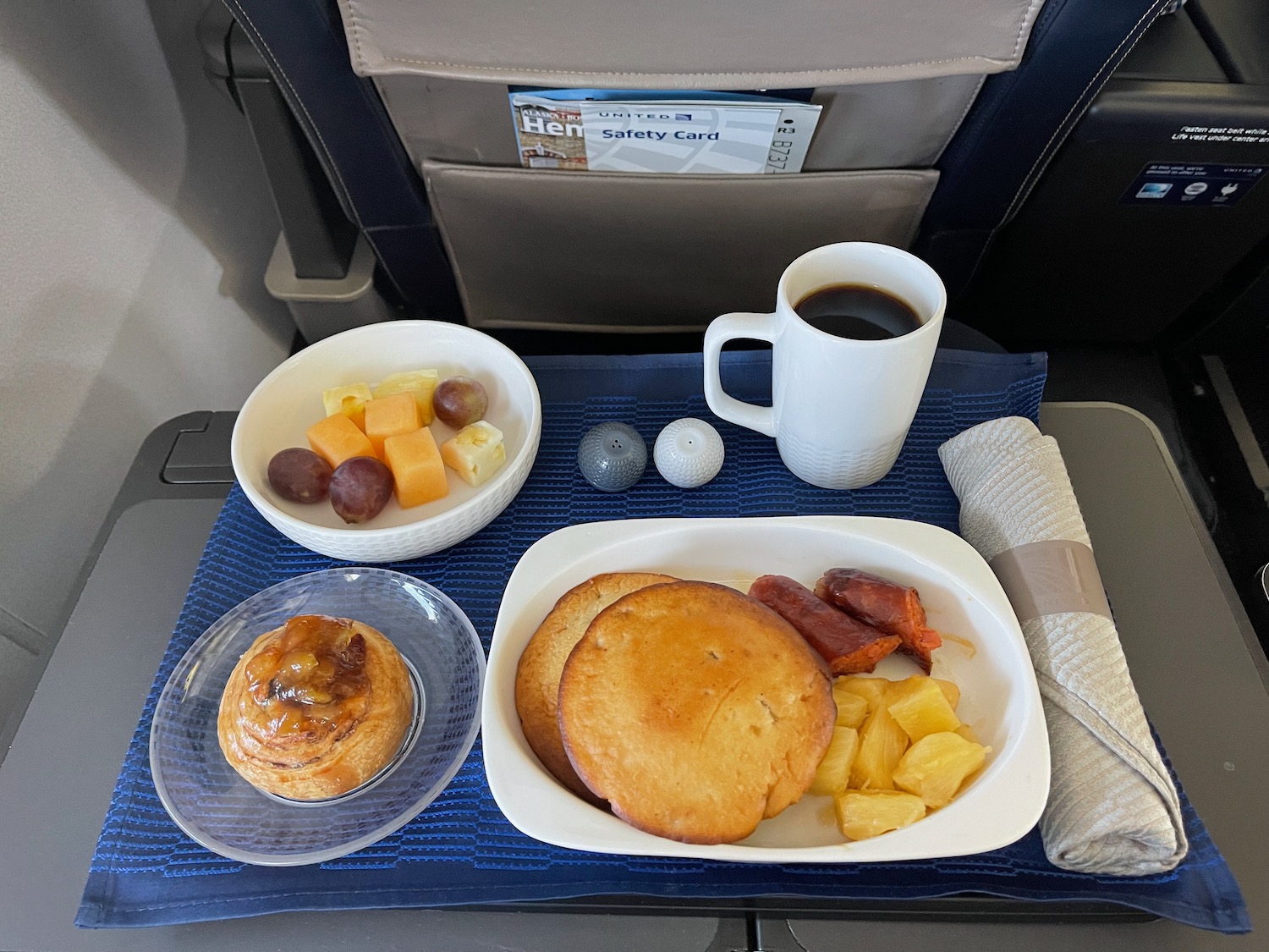 a tray of food and a cup of coffee on a blue place mat