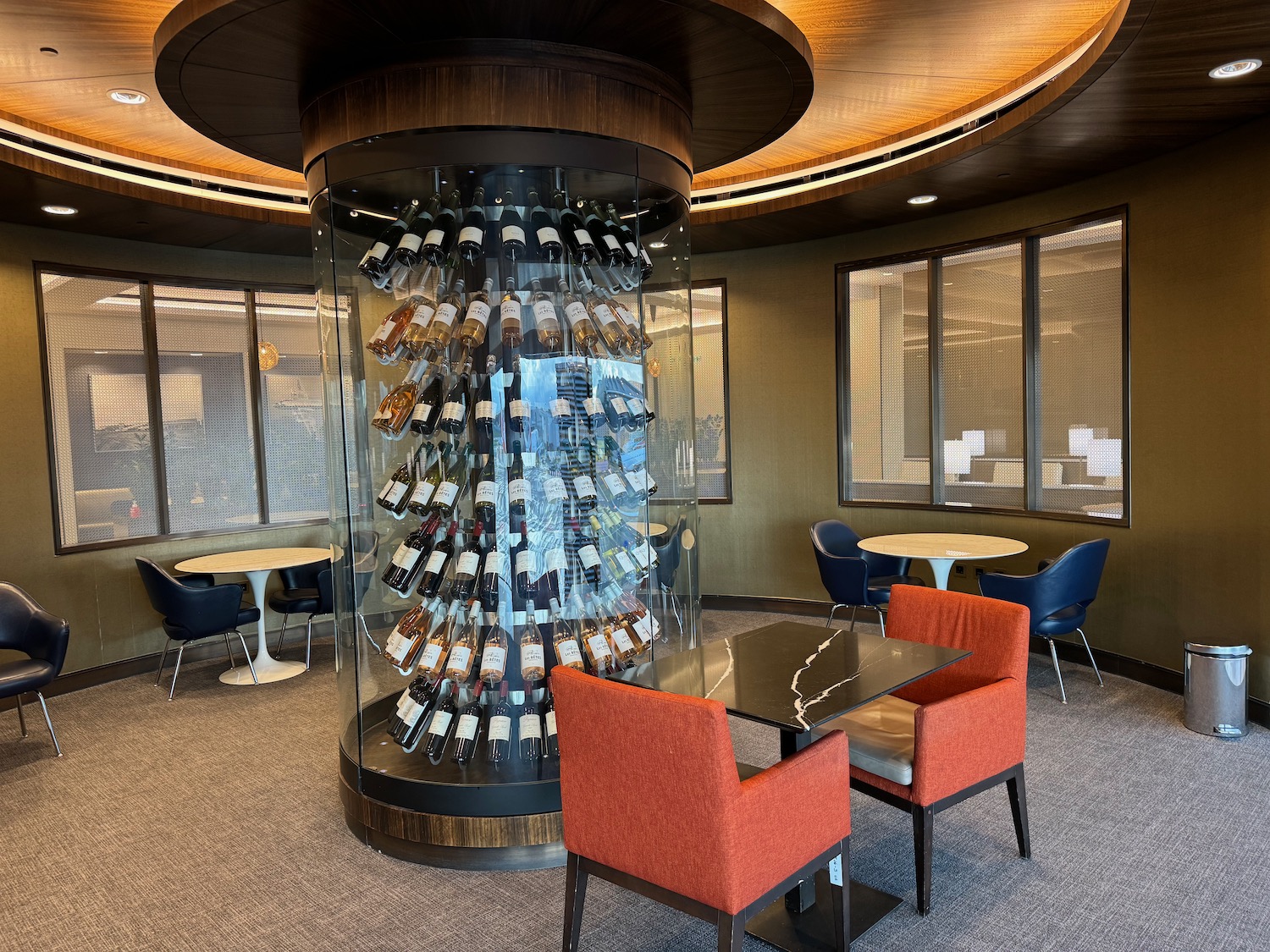 a glass cylinder with wine bottles inside a room