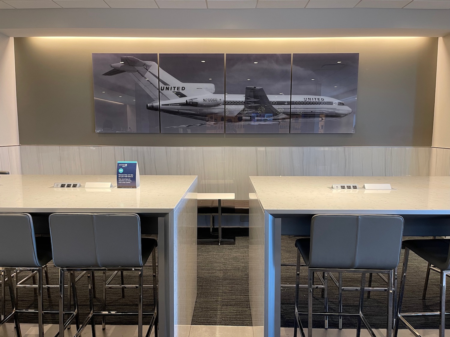 a room with tables and chairs and a picture of an airplane