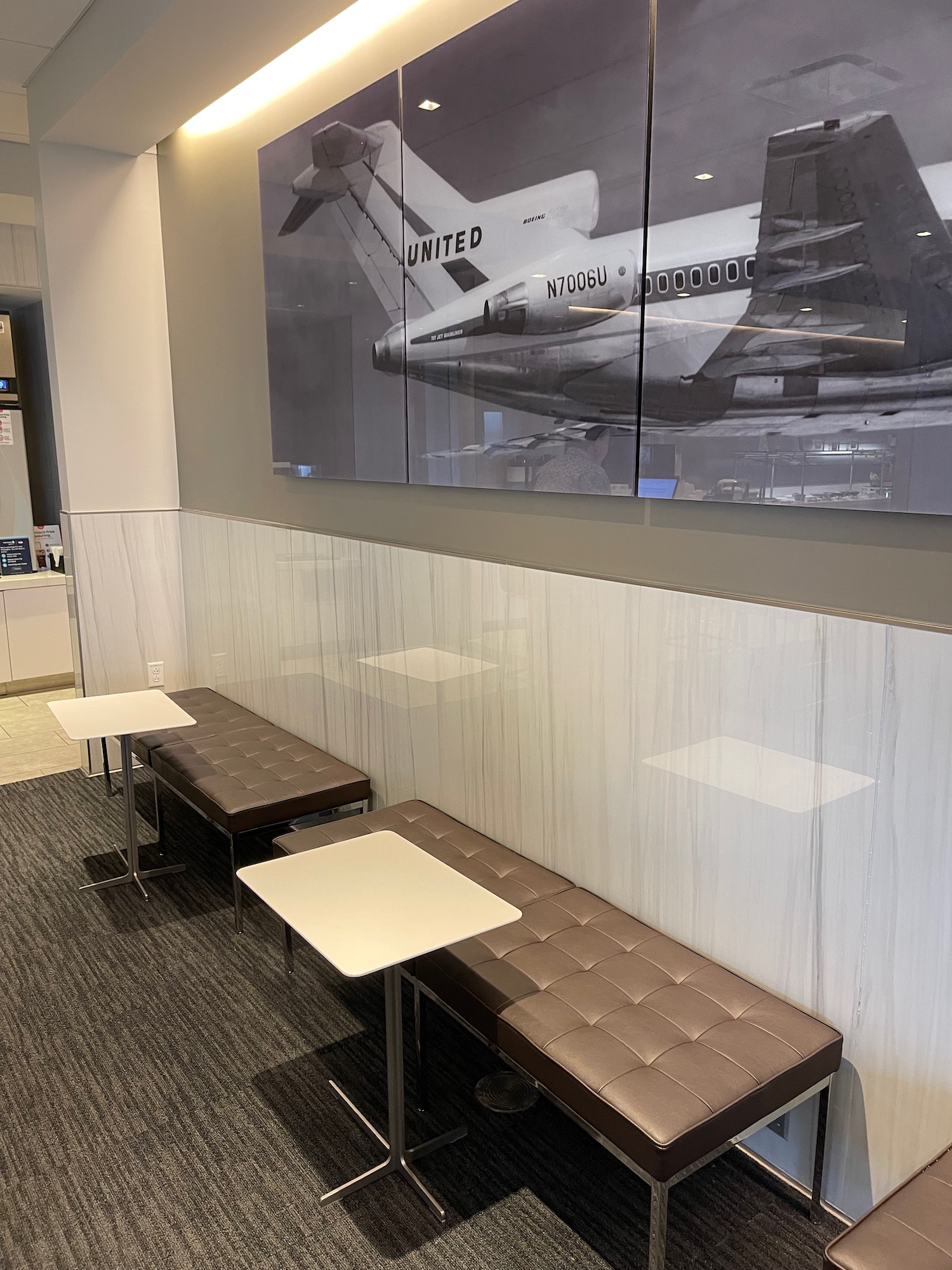 a group of tables and chairs in a room with a picture of an airplane