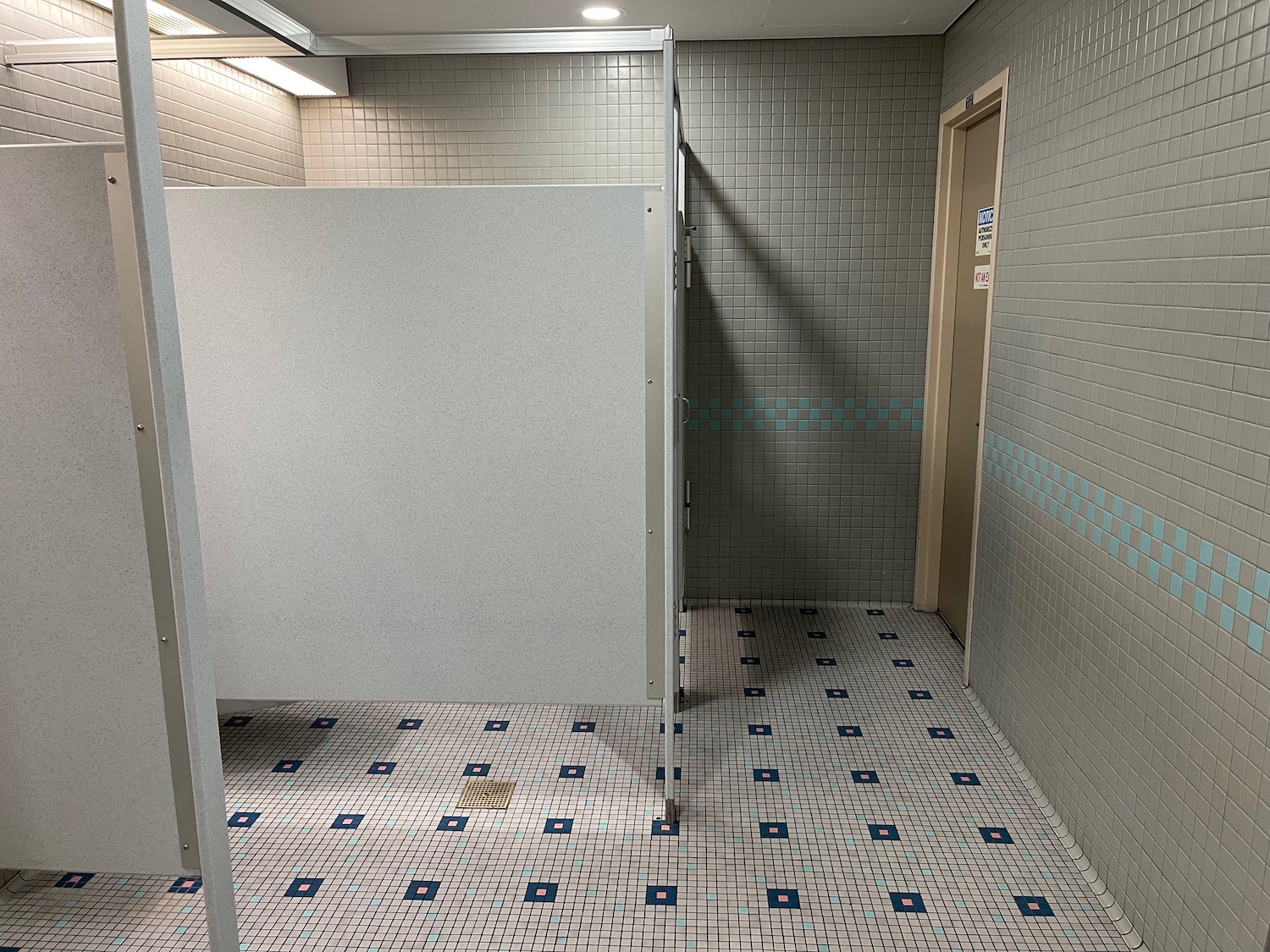 a bathroom with a white wall and blue tiles