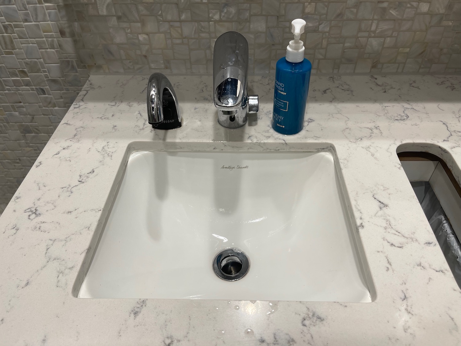 a sink with a soap bottle and a bottle of liquid