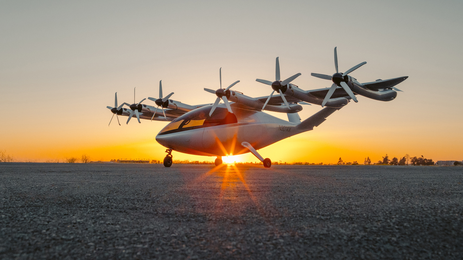 a plane on the ground with the sun setting behind it