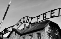 a sign with a flag in front of a brick building