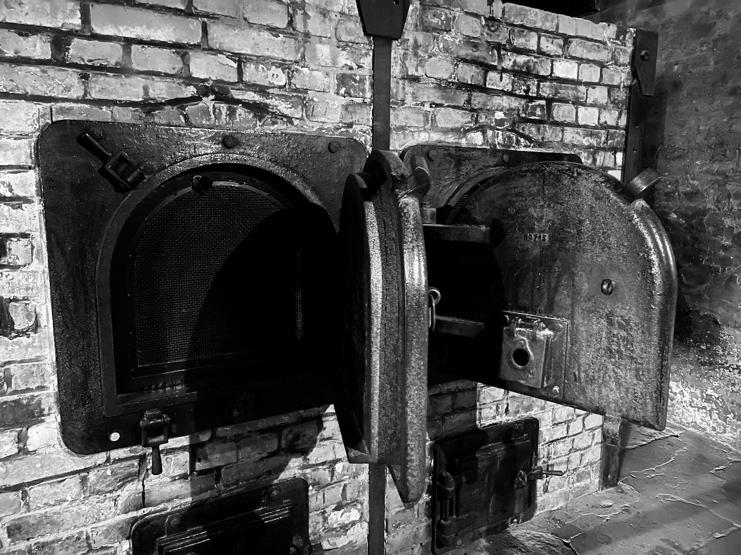 a black and white photo of a brick wall with open doors