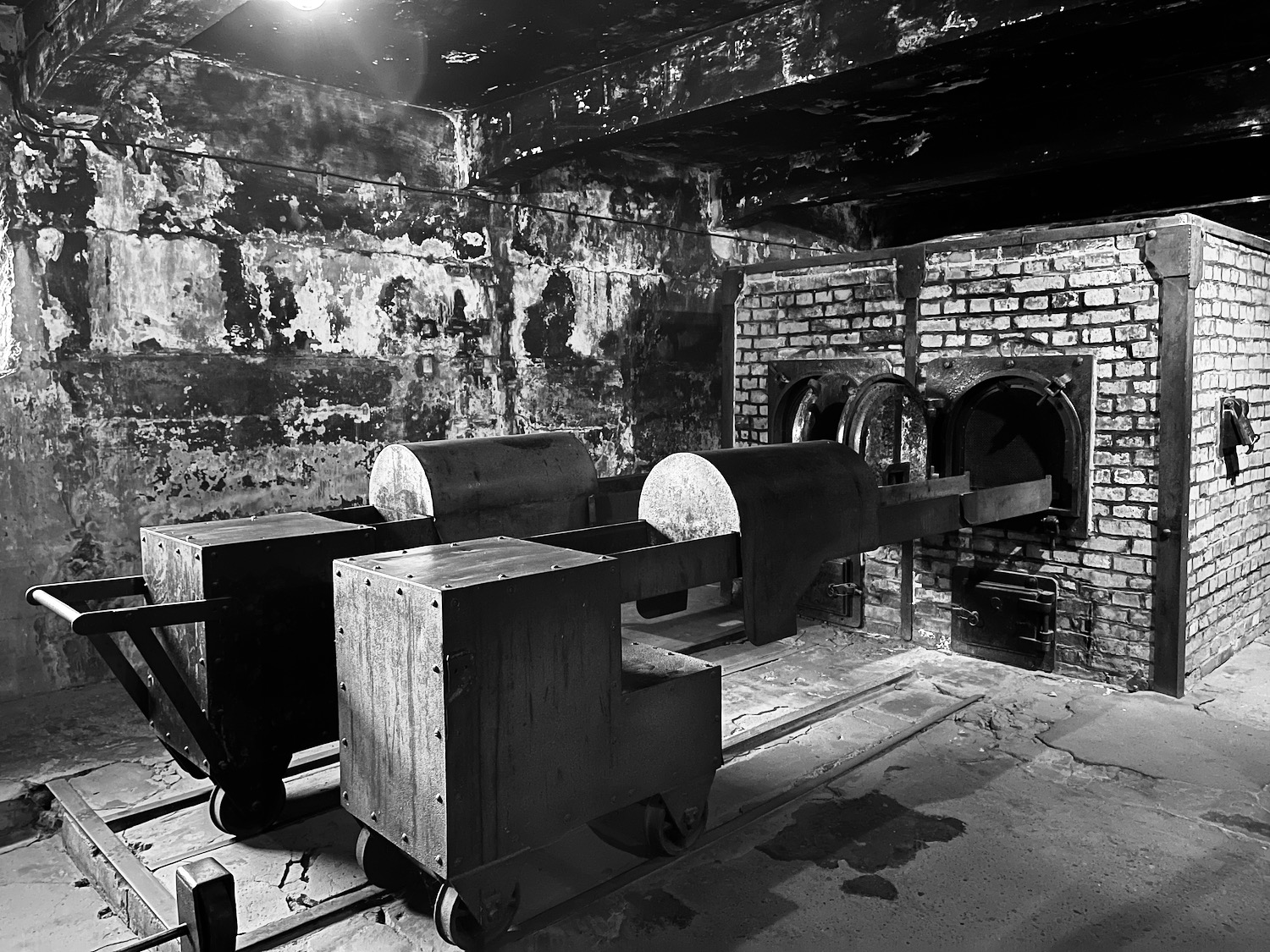 a black and white photo of a brick room with large machines