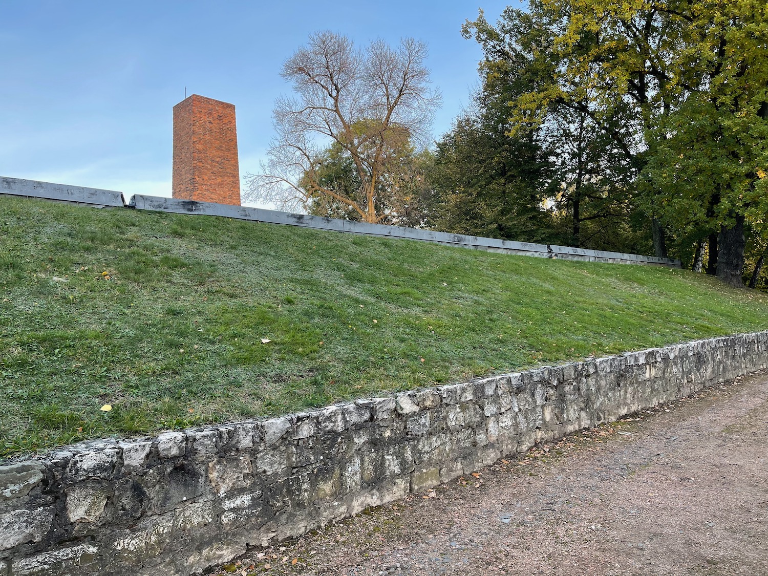 a grass hill with a brick tower in the background