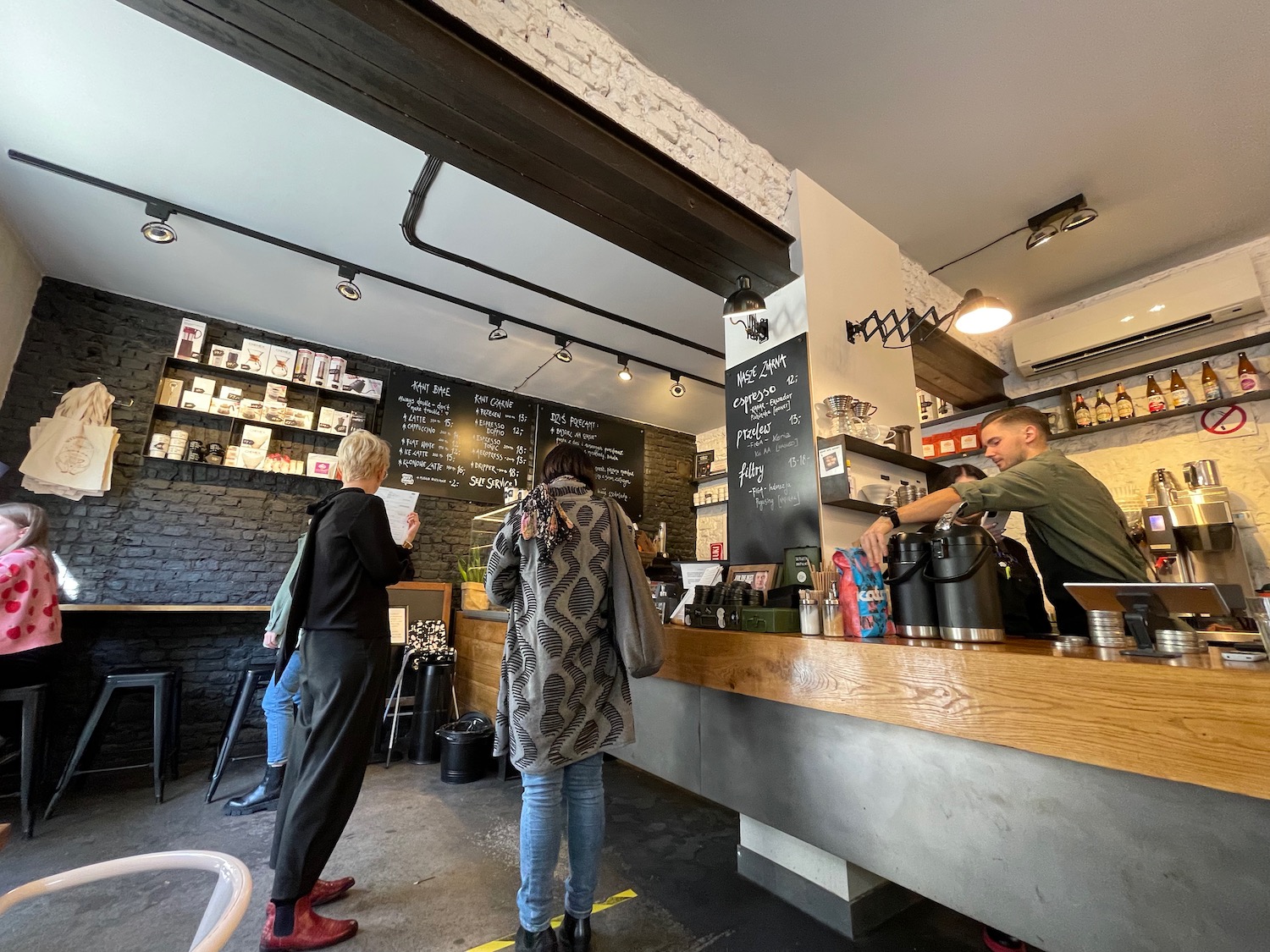 people standing at a counter in a coffee shop