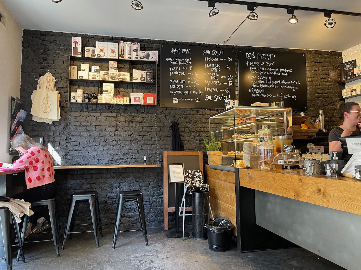 a woman sitting at a counter in a coffee shop