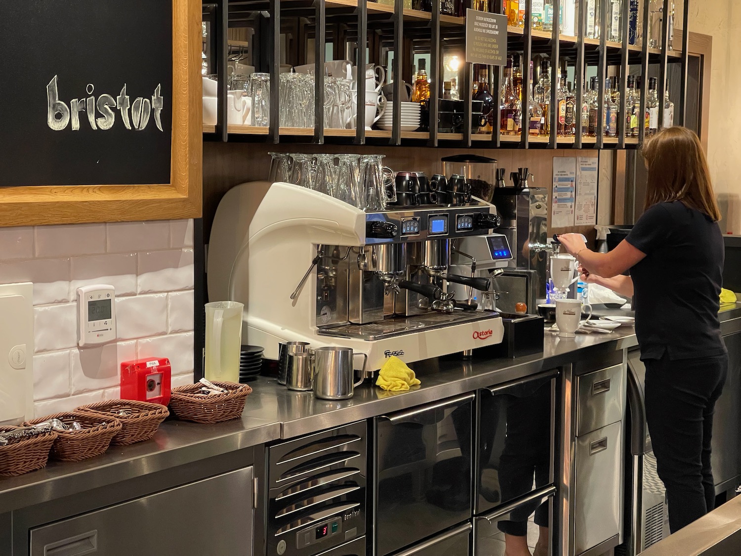 a woman standing in front of a coffee machine