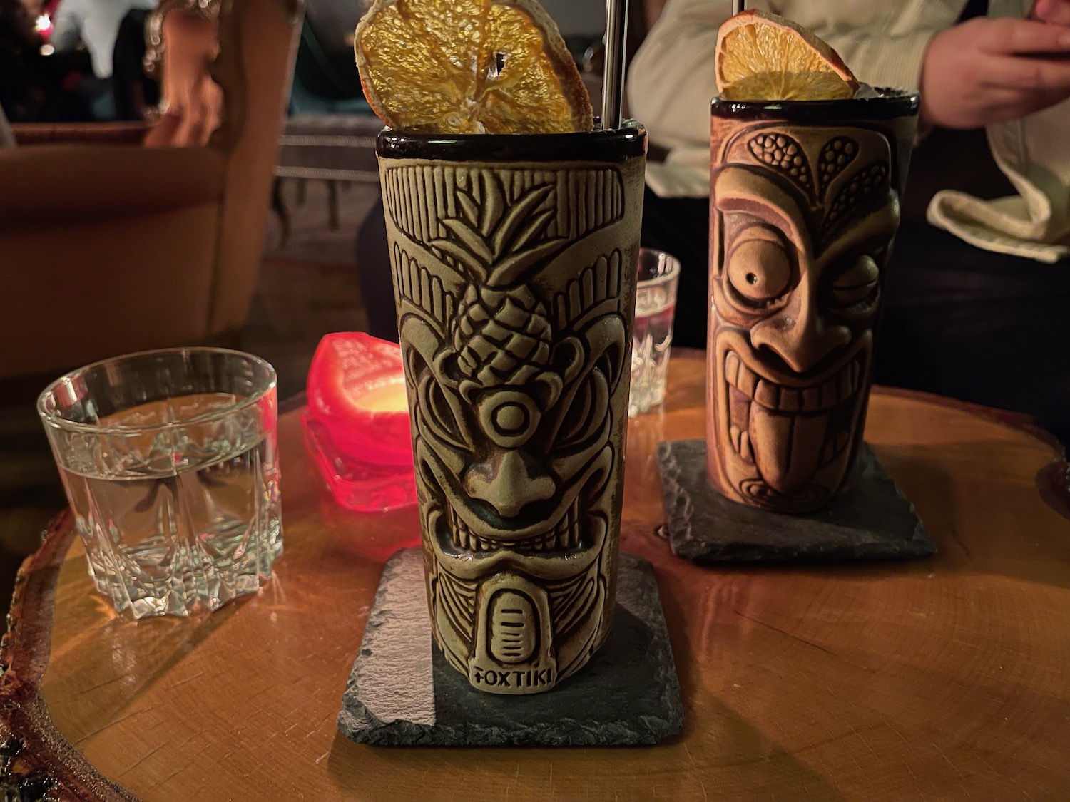a pair of tiki glasses with a straw and orange slices on them