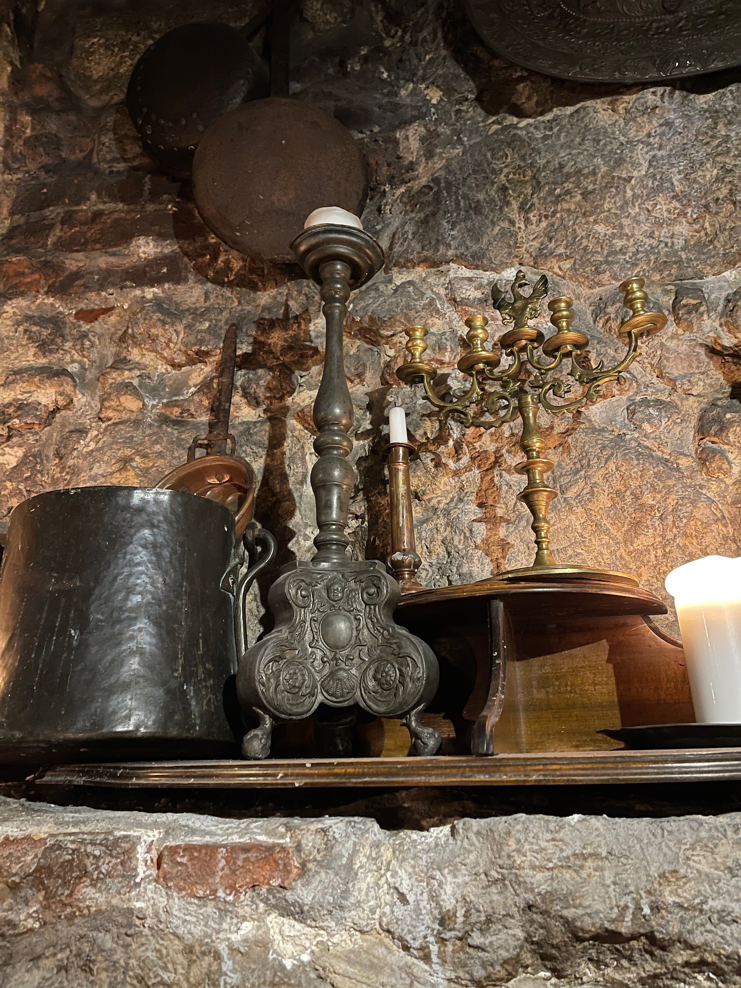 a shelf with candles and a candle holder