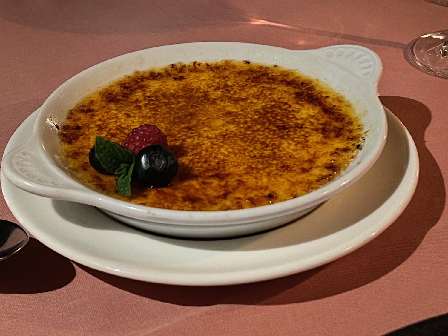 a bowl of creme brulee with berries