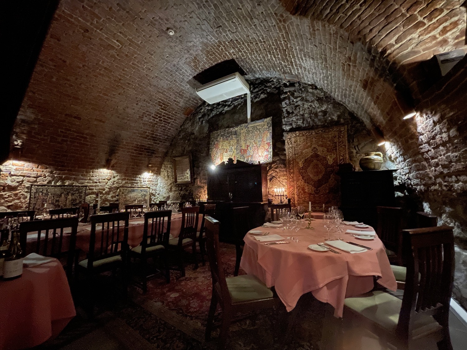 a room with a brick wall and a table set with plates and glasses