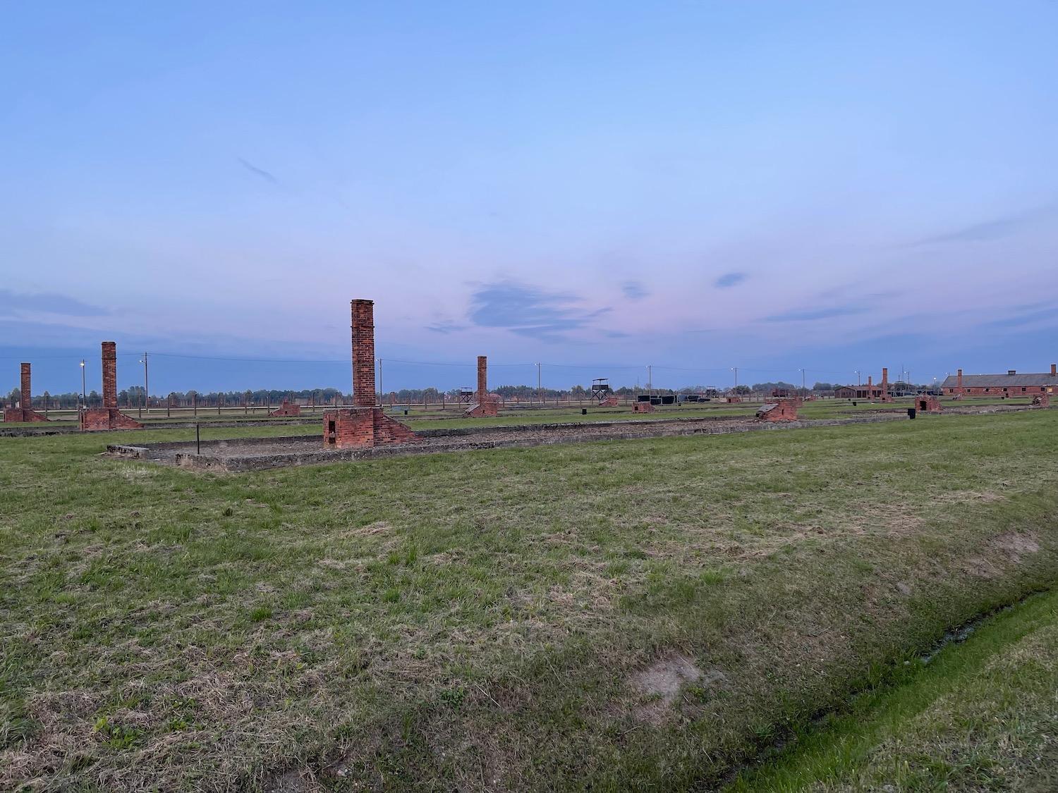 a grass field with brick pillars