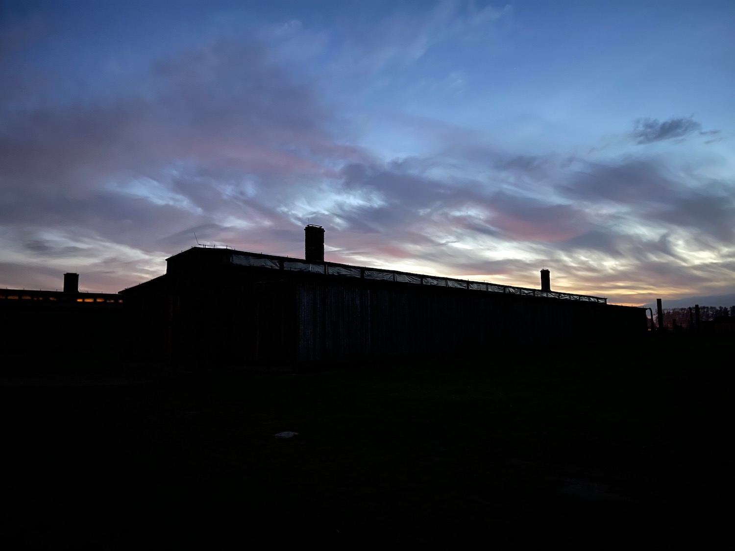 a building with a chimney in the distance